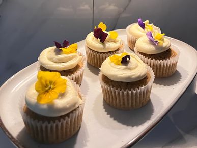 Cupcakes decorated with creamy frosting and edible flowers.