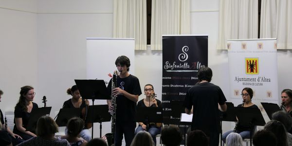 A youth orchestra performing on stage with a clarinet soloist.