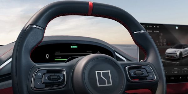 Modern car steering wheel with digital dashboard and touchscreen display.