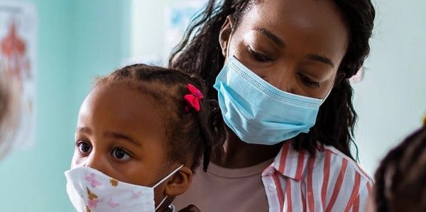 Woman and child wearing masks indoors.