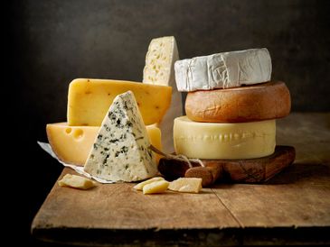 different types of cheese on rustic wooden table
