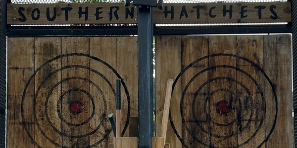 Two wooden target boards for axe throwing under a sign reading Southern Hatchets.