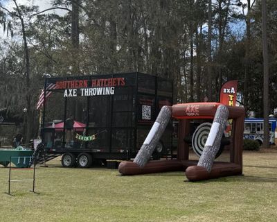 Outdoor setup for Southern Hatchet's axe throwing event in a wooded area.