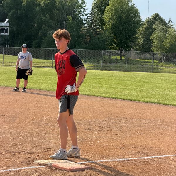 Young baseball player standing on base during practice.