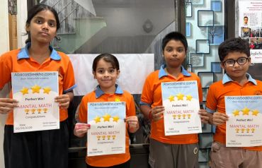 Four children hold mental math certificates, smiling.
