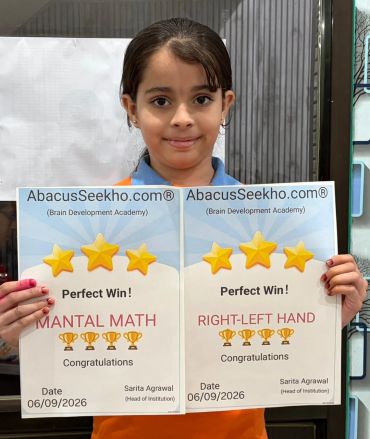 Young girl proudly holding two achievement certificates.