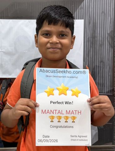 Boy proudly holding a mental math achievement certificate.