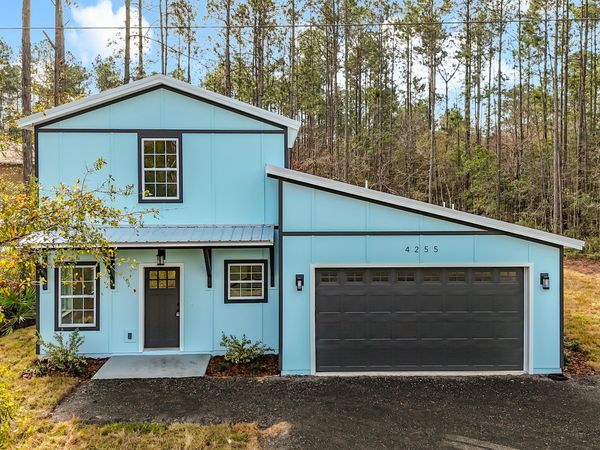 Modern light blue house with black garage door.