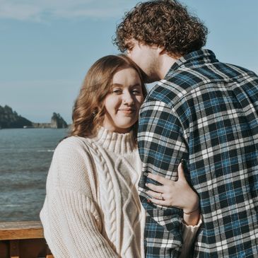 Couple sharing a tender moment by the water.