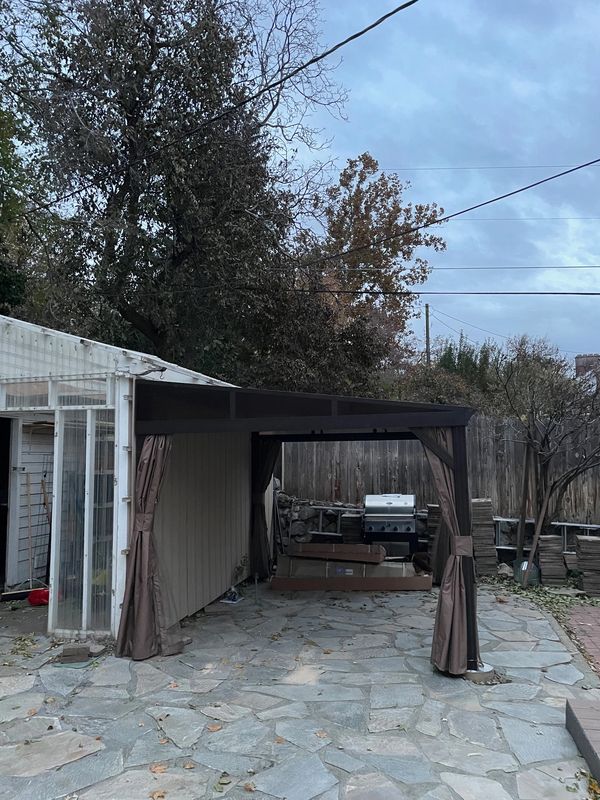 Domi Wall-Mounted Gazebo with curtains and screens on flagstone patio in Ogden, Utah