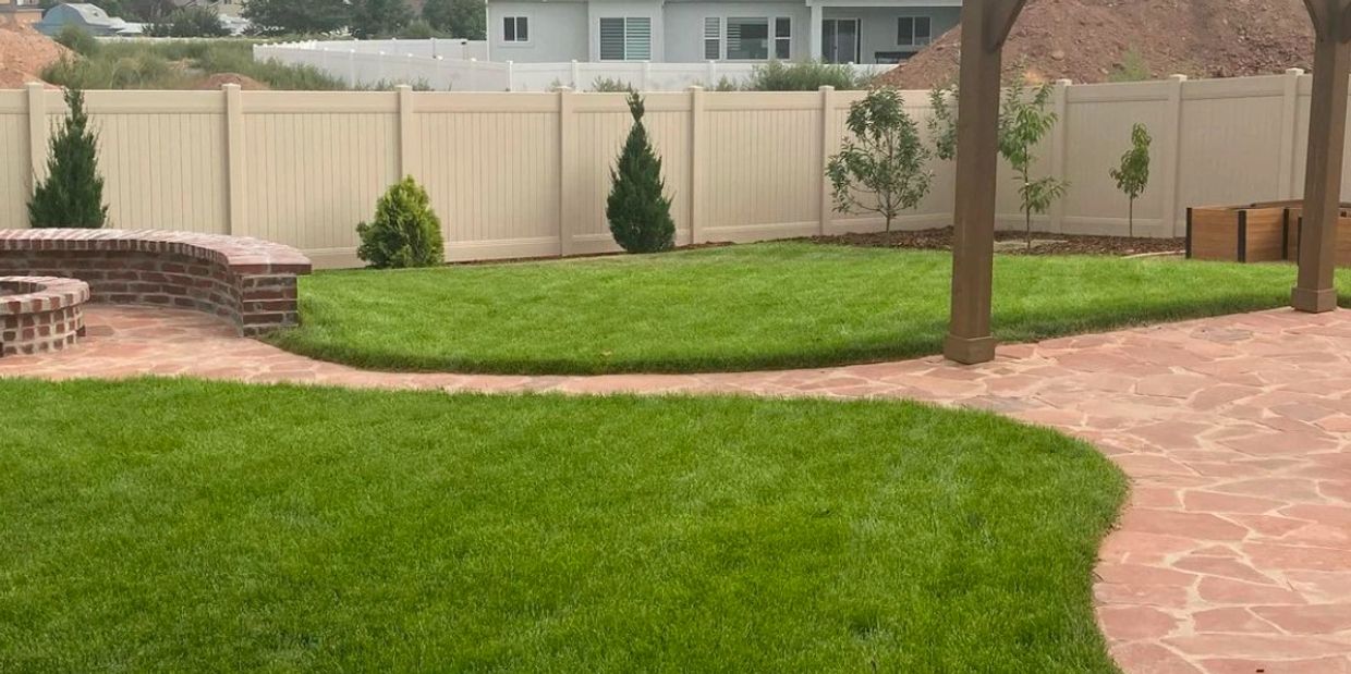Flagstone patio and pathway in beautiful backyard with firepit and pergola in Clearfield, UT