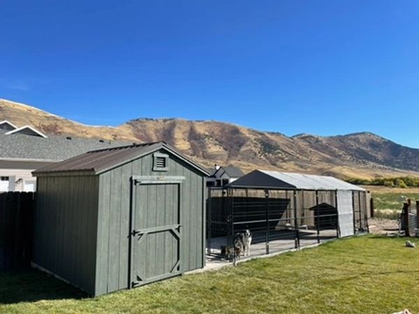 Montana Shed Center A-frame shed with metal roof on concrete slab in Mantua, Utah next to dog run