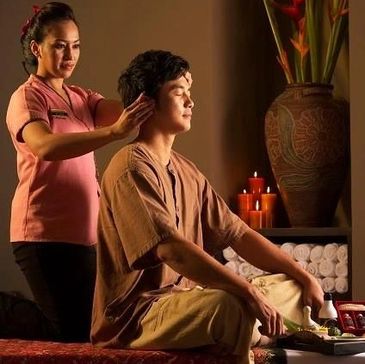 A man receiving a relaxing head massage in a serene spa setting.