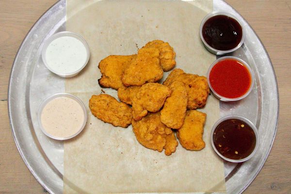 Plate of crispy chicken tenders with dipping sauces at Urbana Brewing Co.