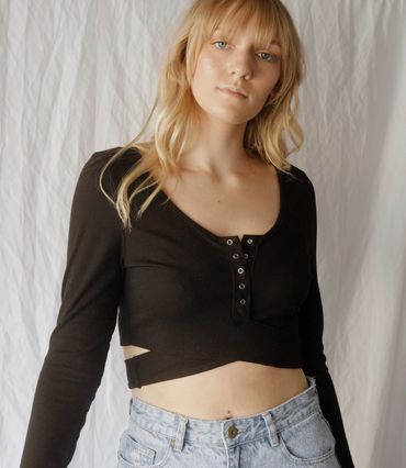 Model posing in a boutique shirt in front of a white backdrop