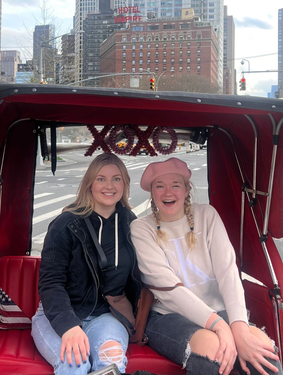 Guests smiling under the XOXO sign on a Gossip Girl Tours NYC tour
