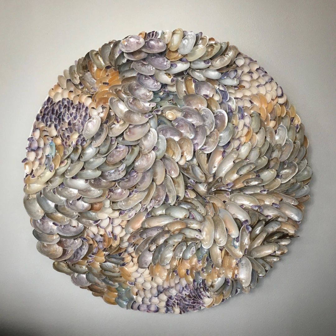 "Schooling Light" is a wall sculpture made of mussel shells.