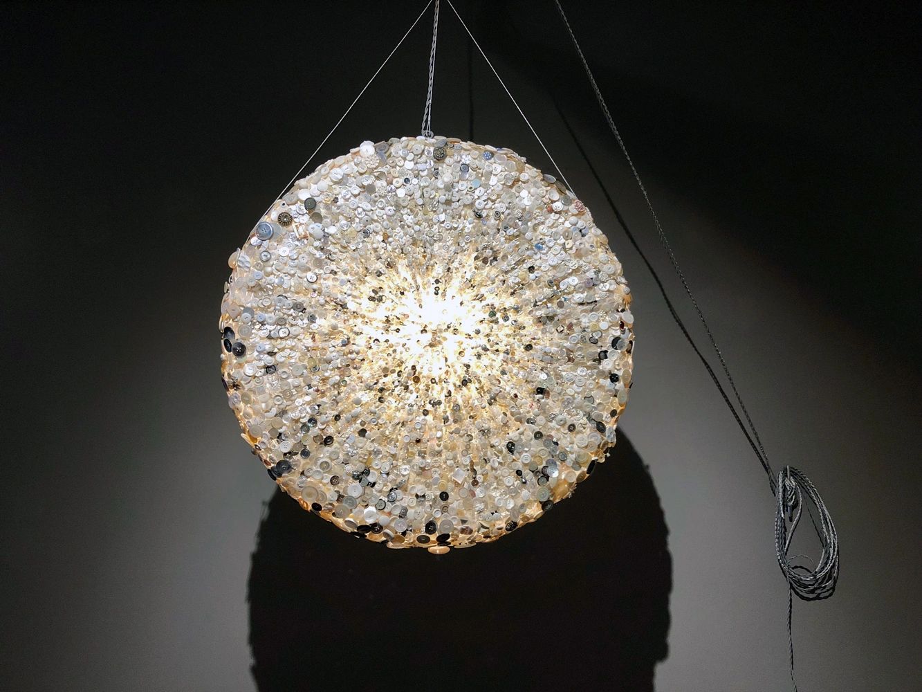 Bouton sculpture made from buttons, jewelry, and light