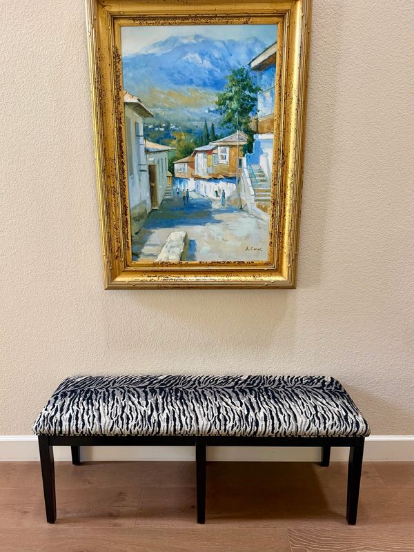 Painting above a zebra-patterned bench.