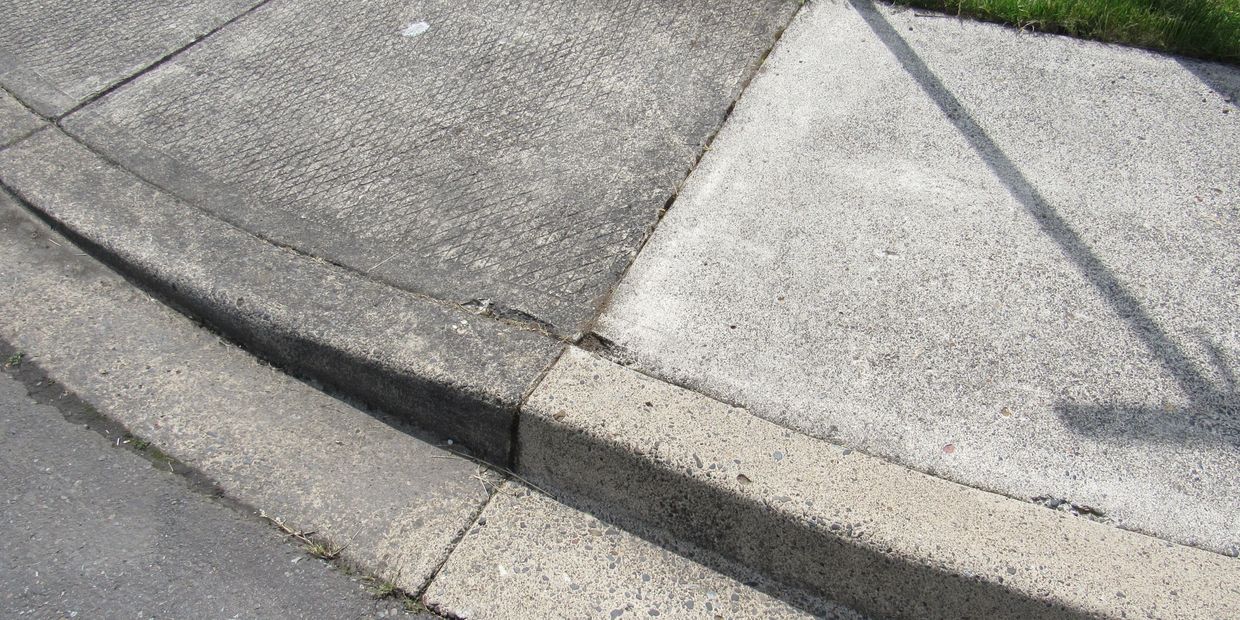 Sidewalk pressure washed on one side and dirty on the other.