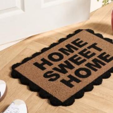 Welcome mat with 'Home Sweet Home' text on wooden floor.