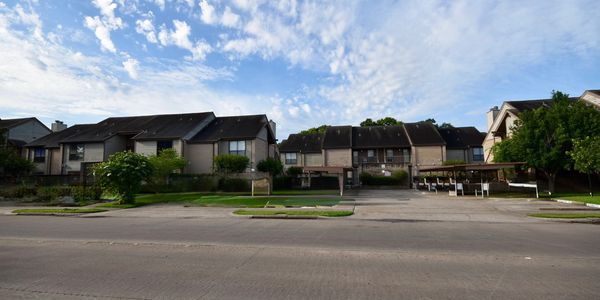 Residential apartment complex under a partly cloudy sky.