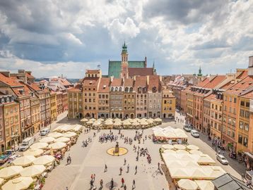 Sunny day at a bustling European town square with historic buildings.