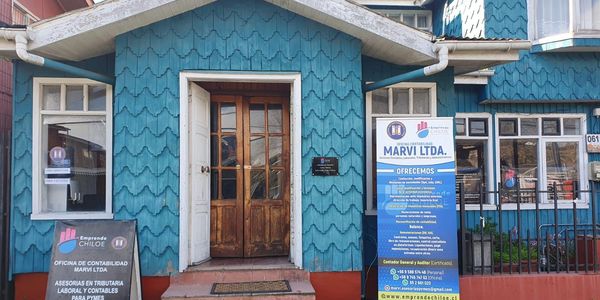 Blue building housing Marvi Ltda. accounting office with wooden door.