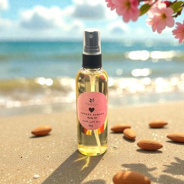 Body oil spray bottle on a beach with almonds scattered around.