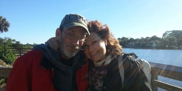 Aynne McAvoy and her husband standing in front of a body of water