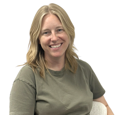 Smiling woman with blonde hair wearing an olive green t-shirt.