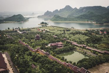 A scenic view of a traditional complex surrounded by greenery and water.