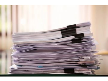 Stack of clipped paper documents.