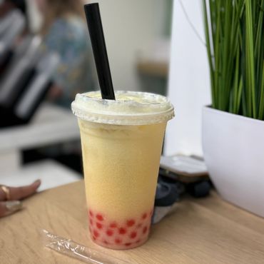 Bubble tea with black straw on table.
