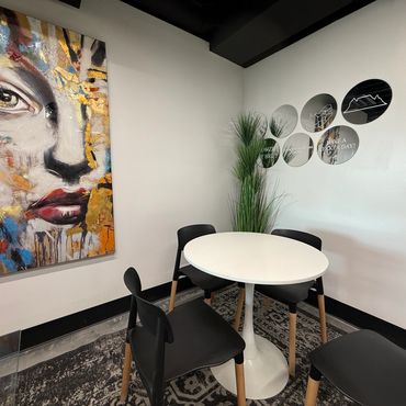 Modern dining area with round table and artwork.