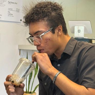 Young man drinking bubble tea inside a cafe.