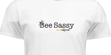 White t-shirt with the text 'Bee Sassy' and bee illustrations. BeeLoved apparel.
