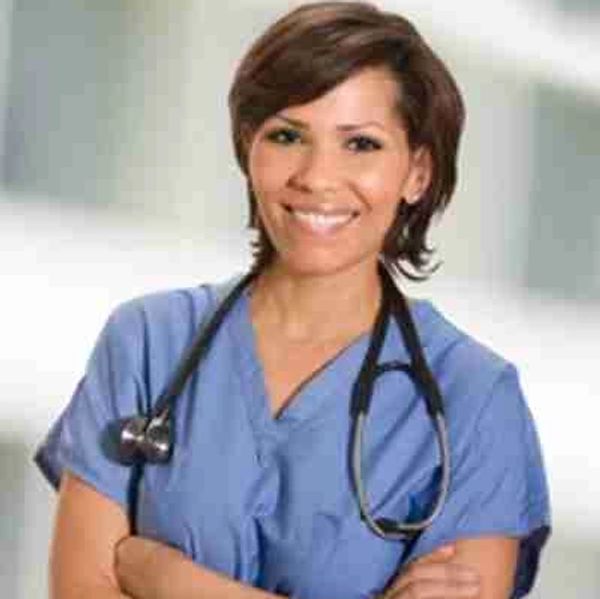 Smiling nurse in blue scrubs with stethoscope.