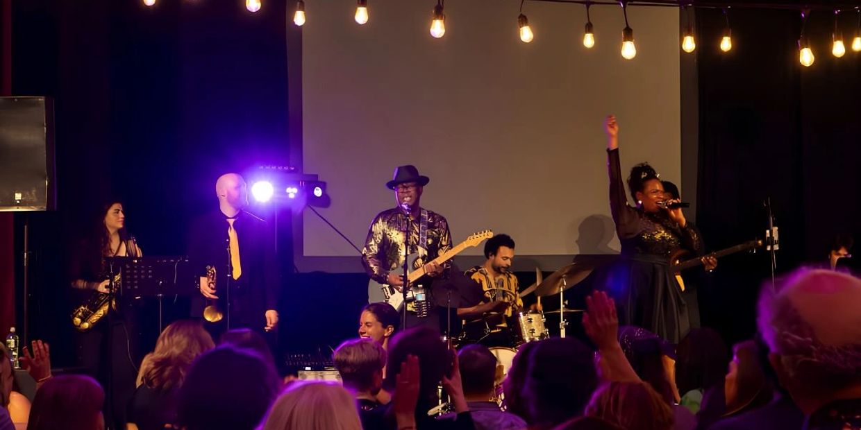 A lively band performs on stage with an enthusiastic crowd.