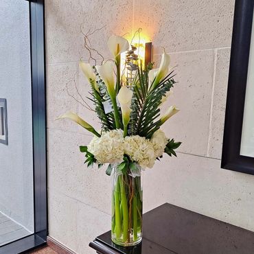 white calla lilies and hydrangeas floral arrangement with curly willow and eucalyptus.