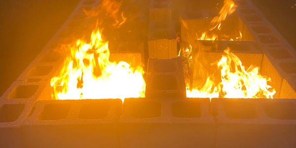 A pit fired kiln on fire at night.