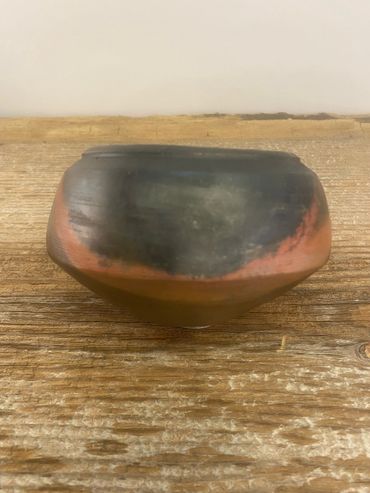 A close up of a pit fired pot.