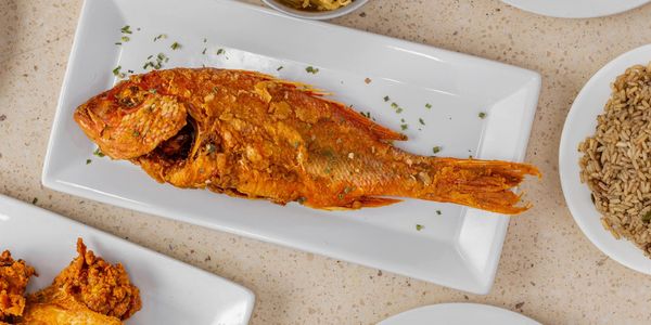 Fried whole fish on a white plate.
