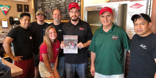 Group of employees posing inside a restaurant.