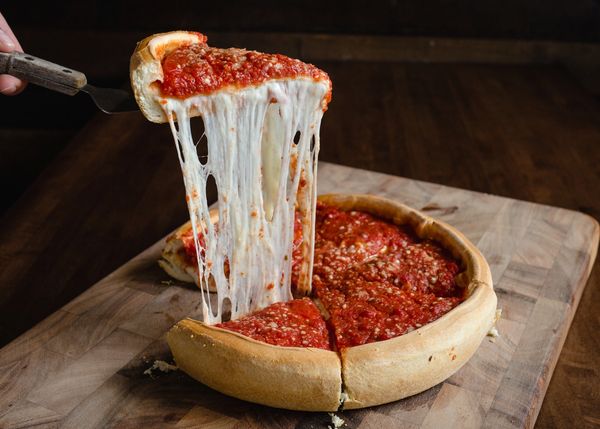 Cheese pull from a deep dish pizza slice.