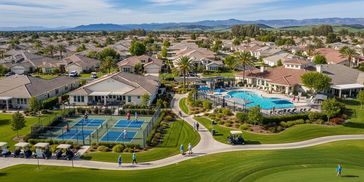 A suburban neighborhood with a golf course, tennis courts, and a swimming pool.