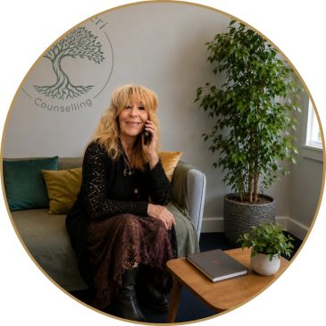 Fiona sitting with phone in her therapy room offering telephone counselling session