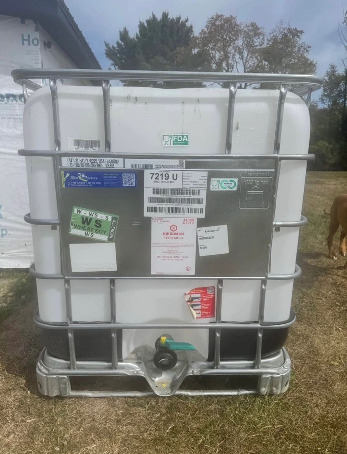 Large container labeled Kikkoman Teriyaki sauce outdoors.