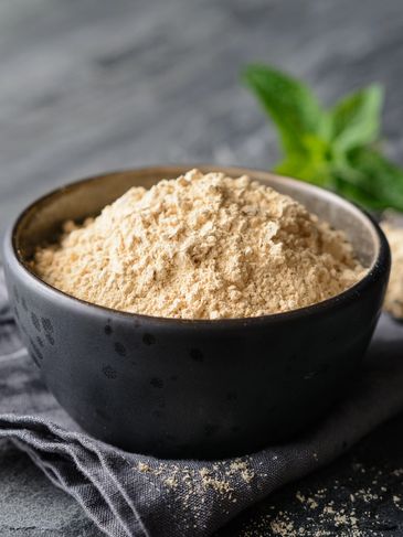 Organic Mondia whitei powder, also known as ground Mulondo root, displayed on slate board