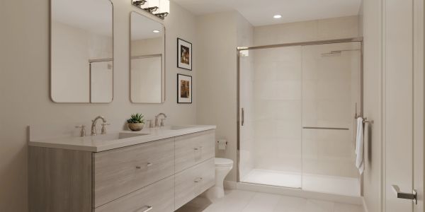 Modern bathroom with double vanity and glass shower enclosure.